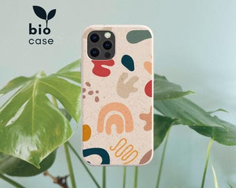May include: A phone case with a speckled beige base featuring an abstract pattern of shapes in red, dark teal, mustard yellow, and light tan. The design includes curved lines, organic blobs, and a rainbow shape. The text bio case is visible.