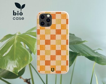 May include: A rectangular phone case featuring a checkered pattern of alternating light yellow and orange squares with a speckled texture. The case has a black camera cutout and a small black U logo at the bottom. The text bio case is visible.