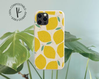 May include: A phone case with a speckled off-white background featuring a repeating pattern of yellow lemons with small green leaves. The case includes a circular logo with the text 100% COMPOSTABLE BAMBOO FIBER and a bamboo stalk icon.