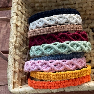 May include: A stack of colorful macrame bracelets in a woven basket. The bracelets are made with different colored cords and have a variety of patterns.