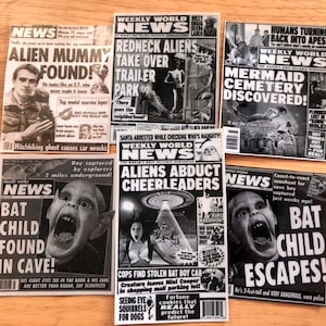 Può includere: Una collezione di ritagli di giornale Weekly World News in bianco e nero con titoli sensazionali. I titoli includono "Alien Mummy Found!", "Redneck Aliens Take Over Trailer Park" e "Bat Child Escapes!". I giornali presentano varie immagini e testo.