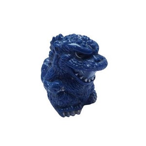May include: A dark blue Godzilla figurine. The toy has a textured, scaly appearance and a detailed face with visible teeth. The figure is set against a plain white background.