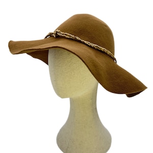 May include: A wide-brimmed hat made of brown felt with a braided rope trim.