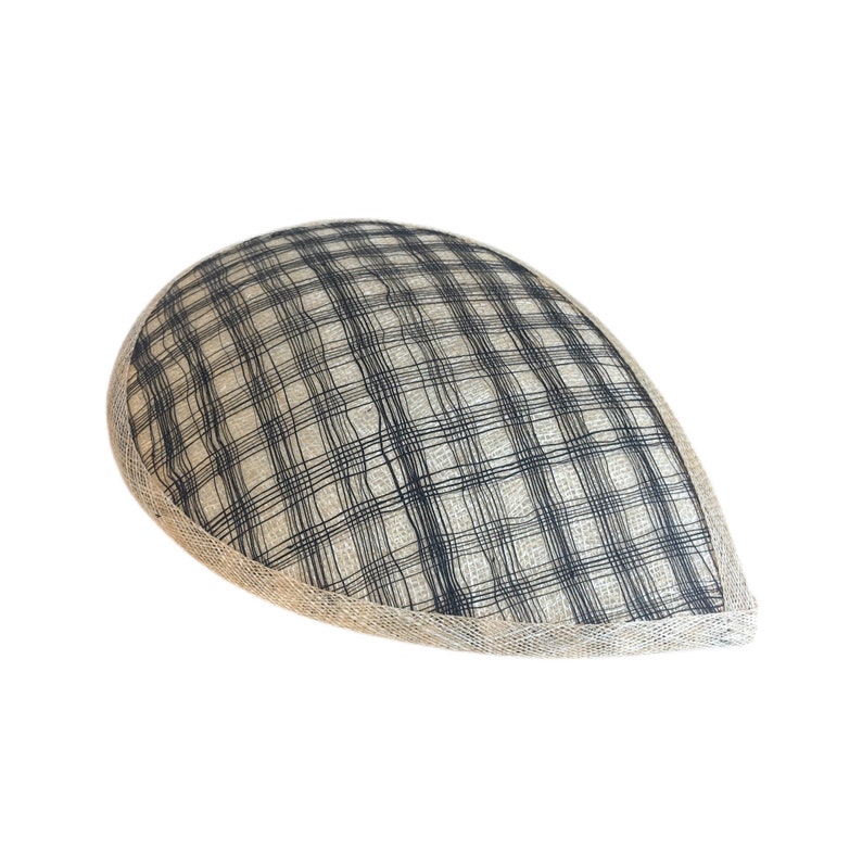 Puede incluir: Un sombrero de tela beige y negro a cuadros, de forma redondeada y ligeramente puntiaguda. El sombrero tiene un ribete beige alrededor del borde.