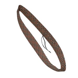 May include: A fabric headband in a brown, red, and black plaid pattern, with a black tag attached. The headband is designed to be worn around the head. The plaid design is a classic pattern.