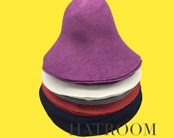 May include: A stack of purple, white, gray, red, and navy blue hat forms. The hat forms are made of a soft, pliable material. The text "HATROOM" is visible at the bottom of the image.