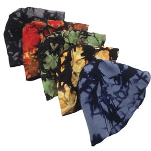 May include: A collection of five tie-dye beanies in various colors. The beanies feature a soft, unstructured design and are dyed in shades of black, red, green, yellow, and blue. The tie-dye pattern creates a unique, artistic look for each hat.
