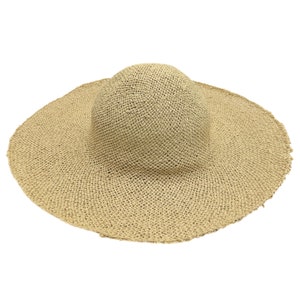 May include: A wide-brimmed straw hat with a woven texture. The hat is a light beige color and has a slightly rounded crown.