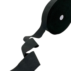 May include: A roll of black elastic trim, a type of fabric used for sewing and crafting projects.