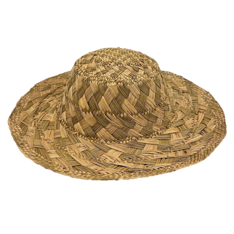 May include: A woven straw hat with a wide brim and a rounded crown. The hat is made of natural-coloured straw and has a textured appearance. The brim measures approximately 38 cm in diameter.