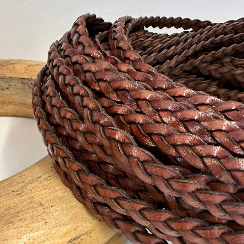 brown braided leather head band. It is made of multiple strands of leather that are woven together to create a thick, durable cord.