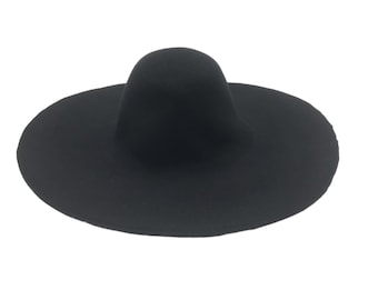 Può includere: Un cappello di feltro nero a larghe falde con una corona arrotondata.