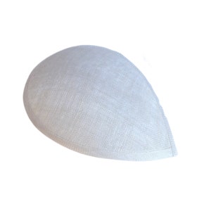 Puede incluir: Un sombrero blanco de forma ovalada hecho de tejido tejido. El sombrero est&aacute; dise&ntilde;ado para ser usado en la cabeza.