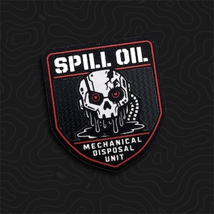 May include: A shield-shaped embroidered patch with a black background and red border. It features a white robotic skull with red eyes dripping black liquid. The text reads SPILL OIL at the top and MECHANICAL DISPOSAL UNIT at the bottom.