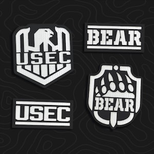 May include: Four embroidered patches featuring black and white designs. Two patches display the text USEC, one with an eagle emblem and one rectangular. Two patches display the text BEAR, one with a claw emblem and one rectangular with horizontal lines.