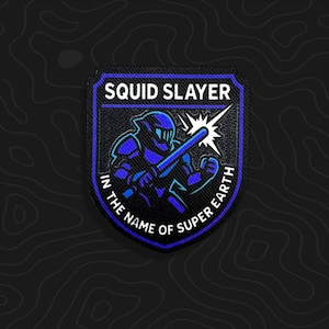 May include: A shield-shaped embroidered patch featuring a blue and black armored figure holding a sword. The text SQUID SLAYER appears at the top, and IN THE NAME OF SUPER EARTH is written along the bottom curve, accented by a white starburst.