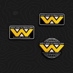 May include: Three embroidered patches featuring the Weyland-Yutani Corp logo. Two rectangular patches display the yellow W emblem and text, while one circular patch includes the logo over a white grid globe with the text Building Better Worlds.