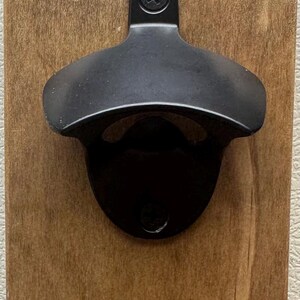 This will be the bottle opener that comes with product. The one with”Open Here” is no longer available.