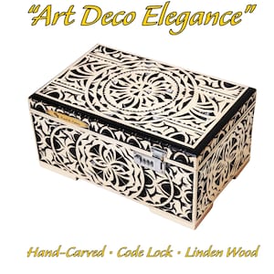 May include: Rectangular wooden box with intricate black and cream-colored Art Deco floral carvings. The box features a code lock and is made of Linden wood. The text "Art Deco Elegance" is displayed above the box.