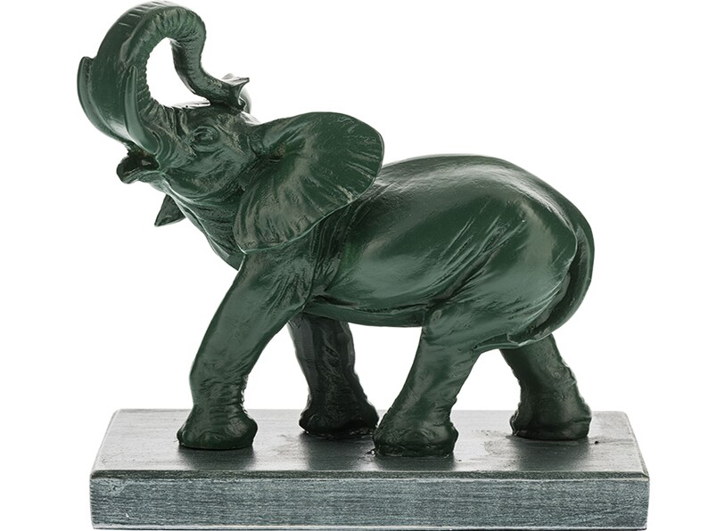 May include: A green ceramic elephant figurine with its trunk raised in the air. The elephant is standing on a square base.