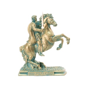 May include: A bronze-colored statue of a man on a rearing horse, holding a spear. The statue has a teal patina and sits on a rectangular base with Greek text. The horse's front legs are raised, and the man is in a classical pose.