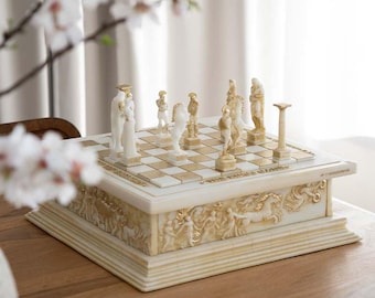 May include: A decorative chess set with ivory and gold accents. The chess board is square with a checkerboard pattern. The chess pieces are sculpted figures. The base of the chess set features relief carvings of classical figures and horses. The set is displayed on a wooden table.