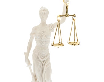 May include: White marble statue of a figure holding a golden scale of justice.
