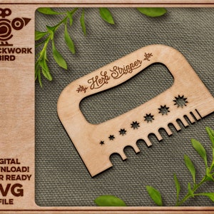 May include: A wooden herb stripper tool with a handle and a row of teeth. The tool is engraved with the words "Herb Stripper" and a small leaf design. The tool is on a brown fabric background.