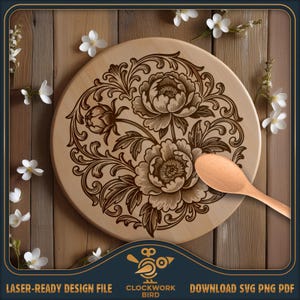 May include: A round light-colored wooden board featuring a dark brown laser-engraved floral pattern of peonies and swirling vines. A smooth wooden spoon rests on the surface. The text "CLOCKWORK BIRD" and "LASER-READY DESIGN FILE" is visible.
