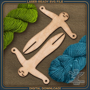 Puede incluir: Dos figuras de madera con caras sonrientes y brazos extendidos. Las figuras están hechas para enrollar hilo y están sobre un fondo de tela marrón. Hay dos ovillos de hilo, uno verde y uno azul, en la imagen.