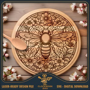 Puede incluir: Una tabla de cortar redonda de madera con un diseño grabado a láser de una abeja central rodeada por un patrón floral circular. Una cuchara de madera clara descansa en el lado izquierdo. El texto Clockwork Bird está en la parte inferior.