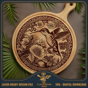 May include: A round wooden serving board with a laser-engraved design featuring a hummingbird in flight surrounded by detailed flowers and leaves. The artwork is enclosed within a decorative circular border. The text Clockwork Bird is visible.