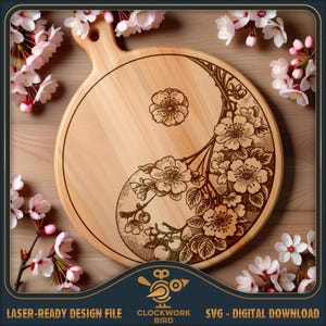 Pode incluir: Uma tábua de corte redonda de madeira com cabo, apresentando um design yin-yang gravado a laser composto por ramos e flores de cerejeira. O texto Clockwork Bird Laser-Ready Design File SVG Digital Download está na parte inferior.
