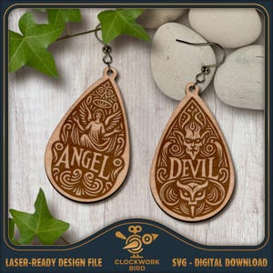May include: A pair of teardrop-shaped wooden earrings featuring laser-engraved designs. One earring displays an angel figure with the text ANGEL, while the other shows a devil figure with the text DEVIL, both accented by intricate scrollwork patterns.