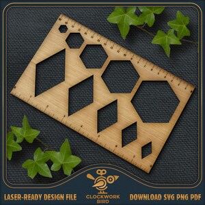Puede incluir: Una regla de madera clara con cortes geométricos, incluyendo hexágonos y diamantes, y una escala de medición en centímetros. El texto "LASER-READY DESIGN FILE" y "CLOCKWORK BIRD" es visible. Hojas verdes de hiedra en el fondo.