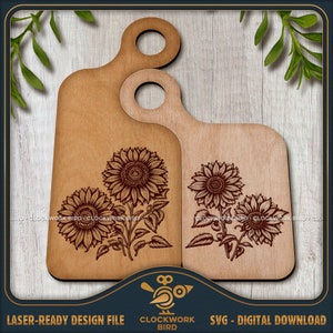 Puede incluir: Dos tablas de cortar de madera con diseños de girasoles grabados. Las tablas tienen un asa en la parte superior y están listas para cortar con láser.