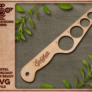 May include: A light-colored wooden spaghetti measuring tool featuring four circular cutouts labeled 1 through 4, with the word Spaghetti engraved in script. The tool includes a small hole at the handle end and the Clockwork Bird logo on the left.