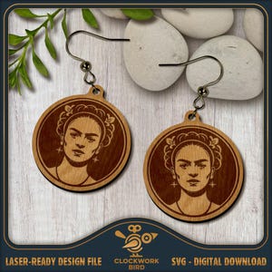 May include: A pair of circular wooden earrings featuring a laser-engraved portrait of a woman with a floral headpiece. The earrings hang from dark metal hooks and display a detailed, monochromatic brown wood grain finish with star accents.