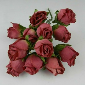 May include: A bunch of 12 small, faux rose buds in a deep burgundy color. The buds are made of fabric and have a realistic appearance.