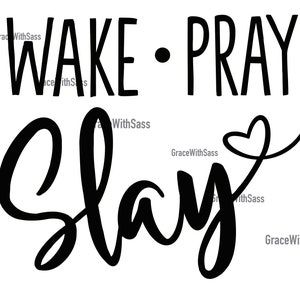 May include: A monochrome graphic featuring the words "WAKE • PRAY SLAY". The word "WAKE" is in a bold, sans-serif font, while "SLAY" is in a cursive script with a heart symbol.