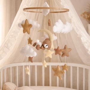 Baby mobile made of felt with a sleeping bear in neutral colors with a moon, stars, and clouds, handmade, gift for birth or baby shower.