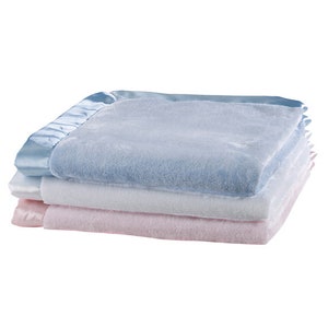 May include: Three soft baby blankets stacked on top of each other. The top blanket is light blue with a satin trim. The middle blanket is white, and the bottom blanket is pink.