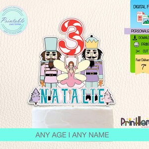 May include: A cake topper featuring a ballerina, two nutcrackers, and the name "Natalie". The number "3" is designed with red and white stripes. The cake topper is a digital file, personalized, and measures 7 inches.