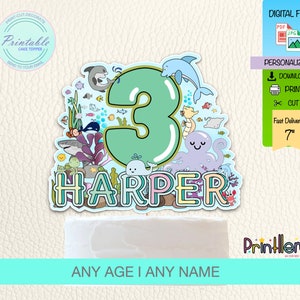 Puede incluir: Topper de pastel imprimible con un número 3 verde rodeado de criaturas marinas coloridas, incluyendo un pulpo, una ballena y un delfín. El nombre "HARPER" está escrito debajo del número. El topper mide 7 pulgadas de alto.