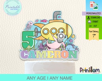May include: Printable cake topper featuring a yellow submarine with a diver, a number 5, and the name Cameron. The design includes various sea creatures like a turtle, octopus, and whale. The topper is 7 inches tall.