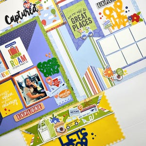 May include: A colorful scrapbook layout with travel-themed embellishments. The design includes the words "Captured," "Explore," and "Let's Go." Decorative elements include a globe, hot air balloons, a scooter, and a taxi cab. The layout features various patterned papers and photo spaces.