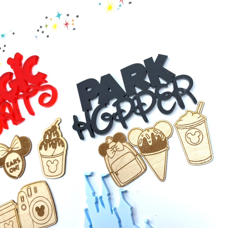 Op de afbeelding: Zwarte "Park Hopper" belettering met een Mickey Mouse-kopontwerp.  Houten uitsnijdingen van een Mickey Mouse-ijsje, een Mickey Mouse-ijsbeker, een Mickey Mouse-rugzak en een Mickey Mouse-milkshake.
