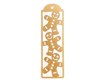 May include: A tan-colored bookmark with a rectangular cutout featuring three gingerbread men. Each gingerbread man has a smiling face and is cut out of the bookmark. The top of the bookmark has a rounded shape with a hole.