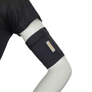 Op de afbeelding: Zwarte armbanden met een klein grijs label met de tekst "dlace".