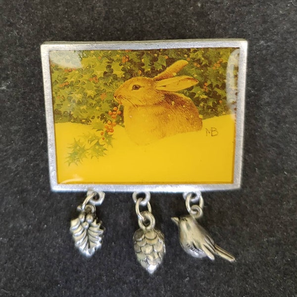 Hallmark Marjolein Bastin Rabbit in Snow Brooch/Pin. Rectangular Frame with Pewter Hanging Leaf, Pine Cone, and Bird Charms. Resin Coated.